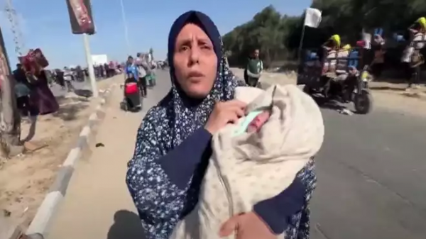 جدة فلسطينية تحمل أصغر نازحة في غزة