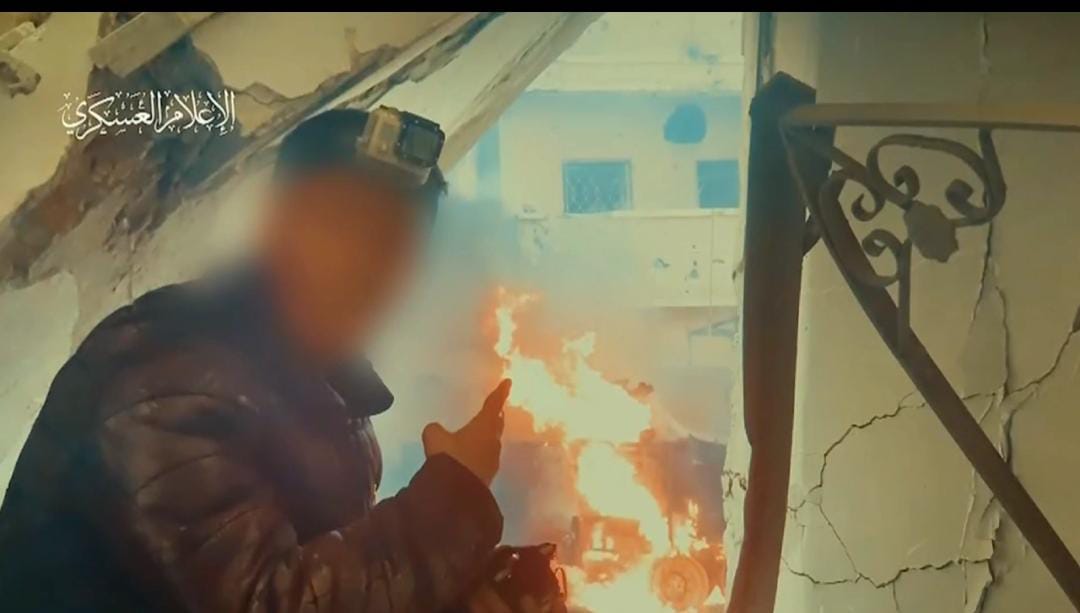 مقاتل قسامي يلتقط سيلفي مع دبابة صهيونية محترقة اثناء المعارك في الشجاعية
